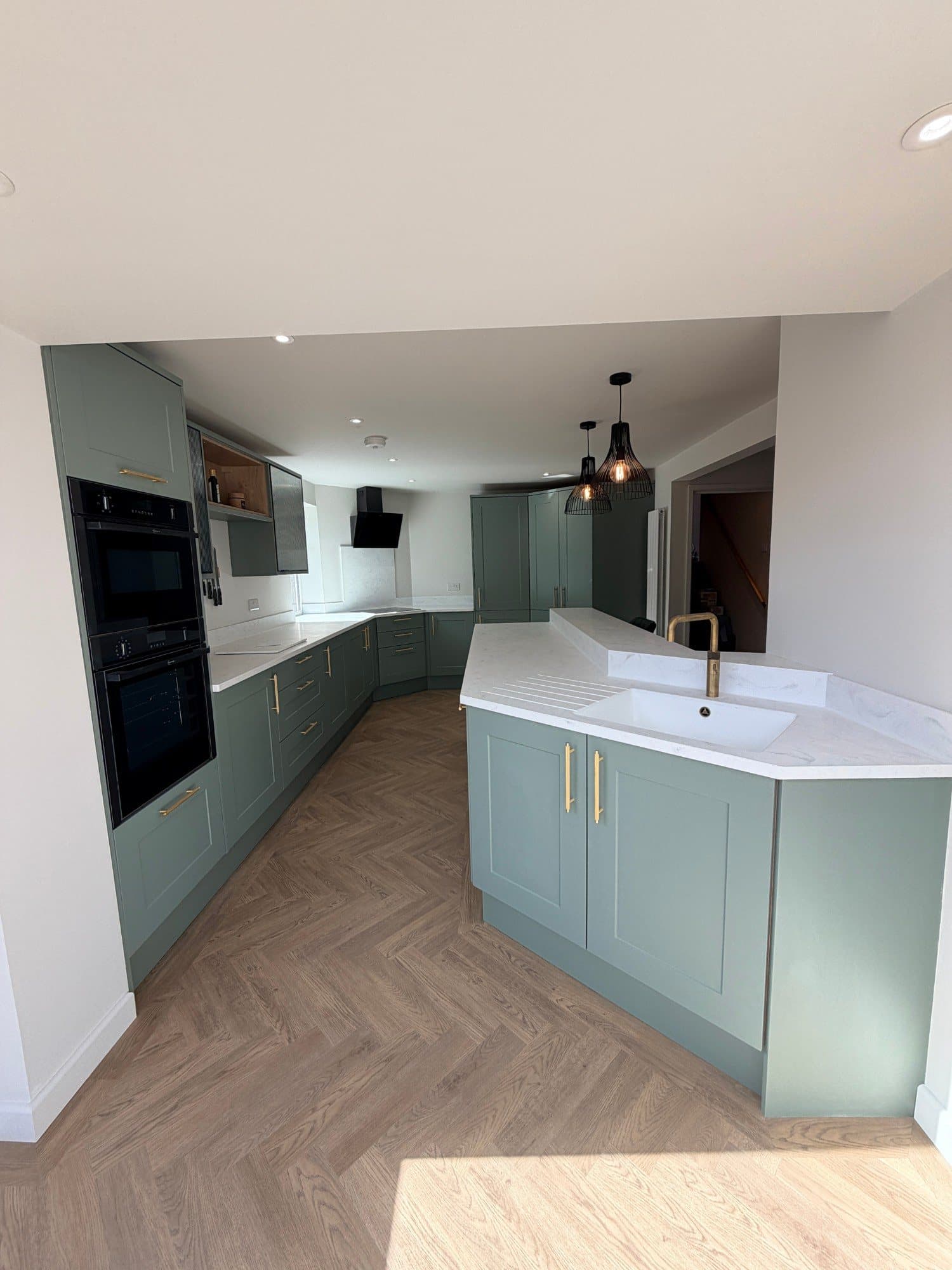 Open-plan kitchen and dining area with pendant lighting and a corner pantry unit